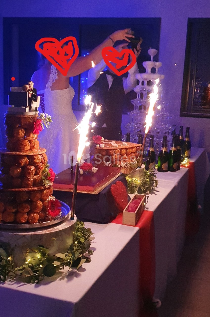 Table décorée pour un mariage avec pièce montée, fontaine de champagne et bougies scintillantes.
