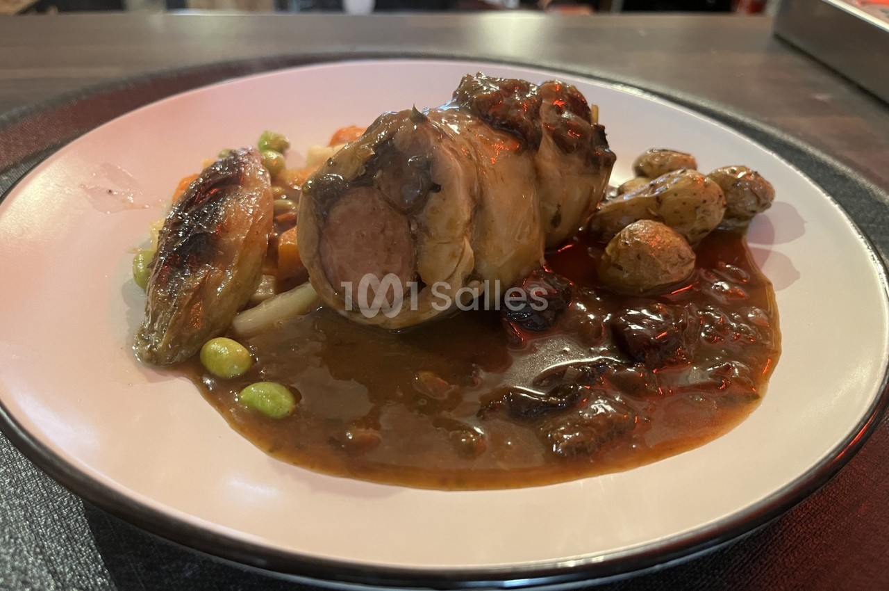 Assiette de viande roulée avec sauce brune, légumes verts, pommes de terre rôties et endive braisée.