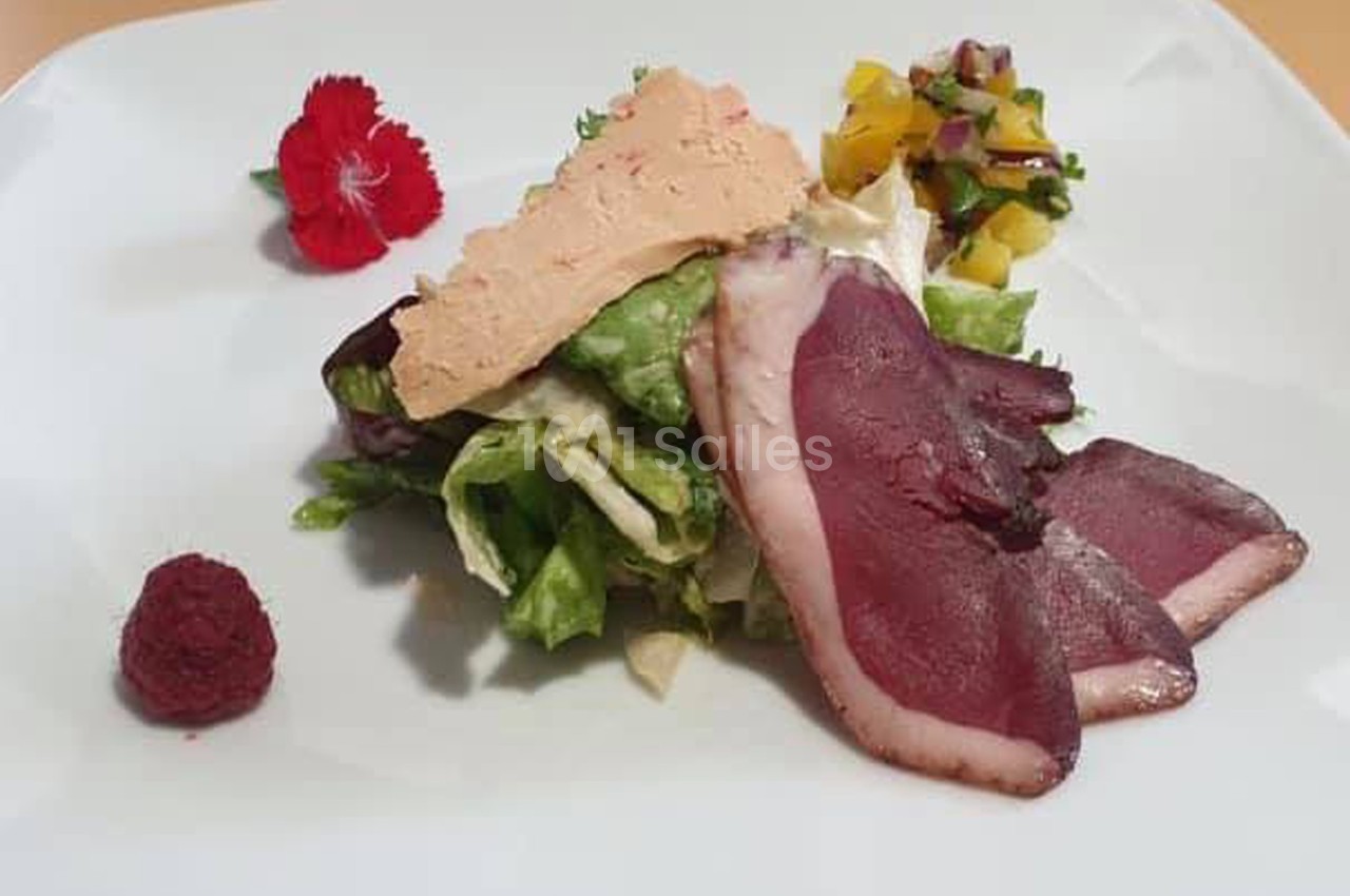 Assiette composée de magret de canard fumé, foie gras, salade verte, chutney de mangue et framboise.