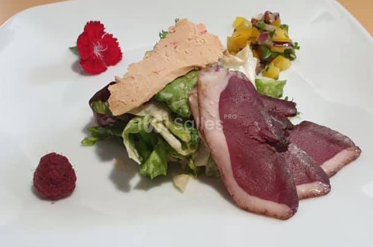 Assiette composée de magret de canard fumé, foie gras, salade verte, chutney de mangue et framboise.