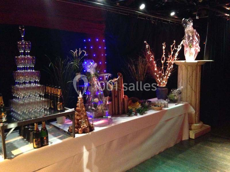 Table décorée pour un événement avec pyramide de verres, bouteilles de champagne et sculptures lumineuses.