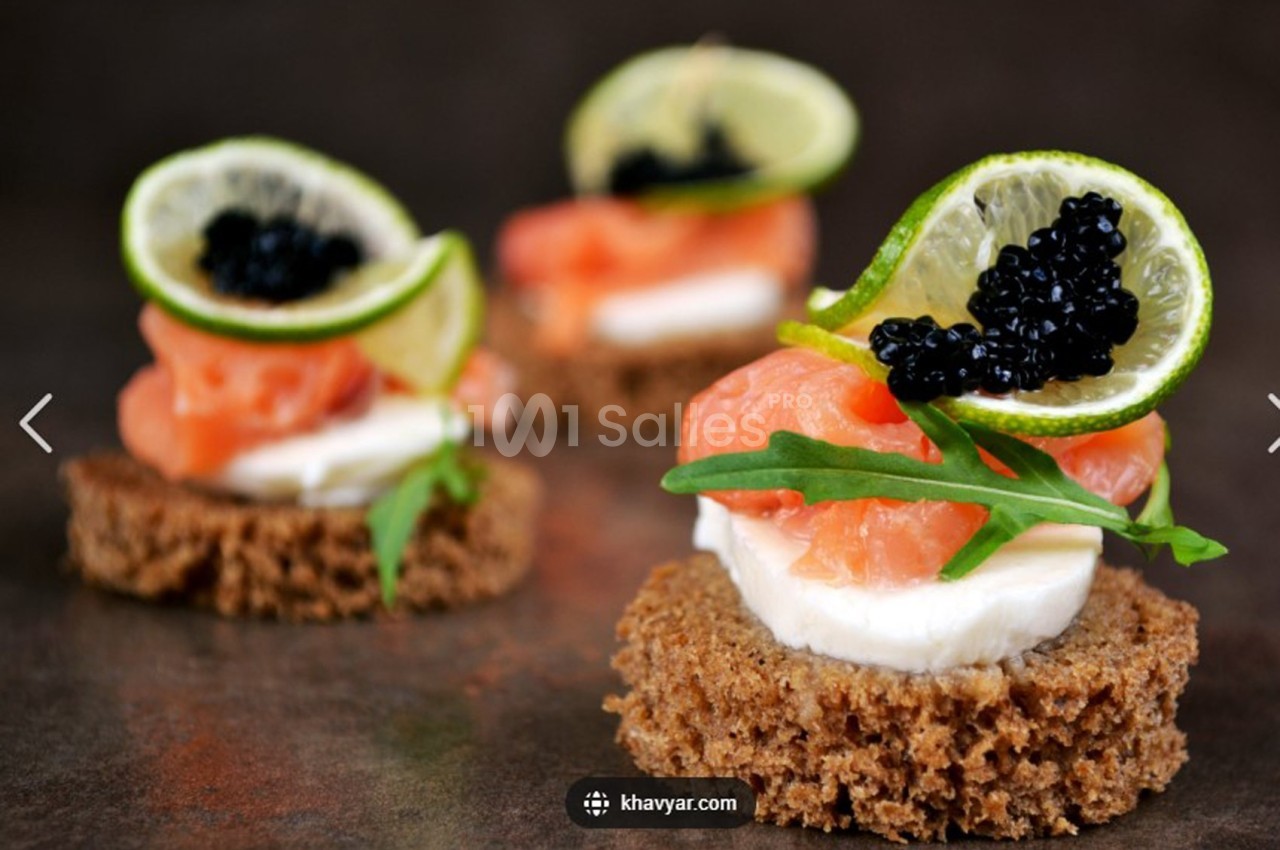 Canapés sur pain de seigle garnis de fromage, saumon fumé, citron vert, œufs de poisson et roquette.