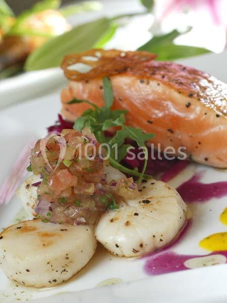 Assiette gastronomique avec saumon grillé, noix de Saint-Jacques, tartare de légumes et décor de sauces colorées.