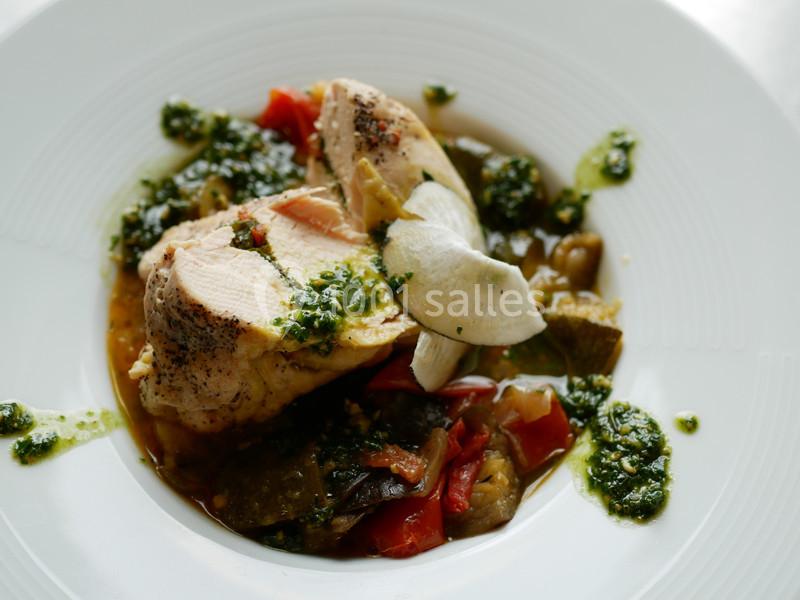 Assiette de poulet rôti accompagné de légumes variés et d'une sauce verte au pesto.