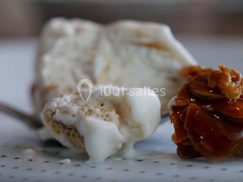 Glace fondante accompagnée de caramel croquant sur une assiette blanche.