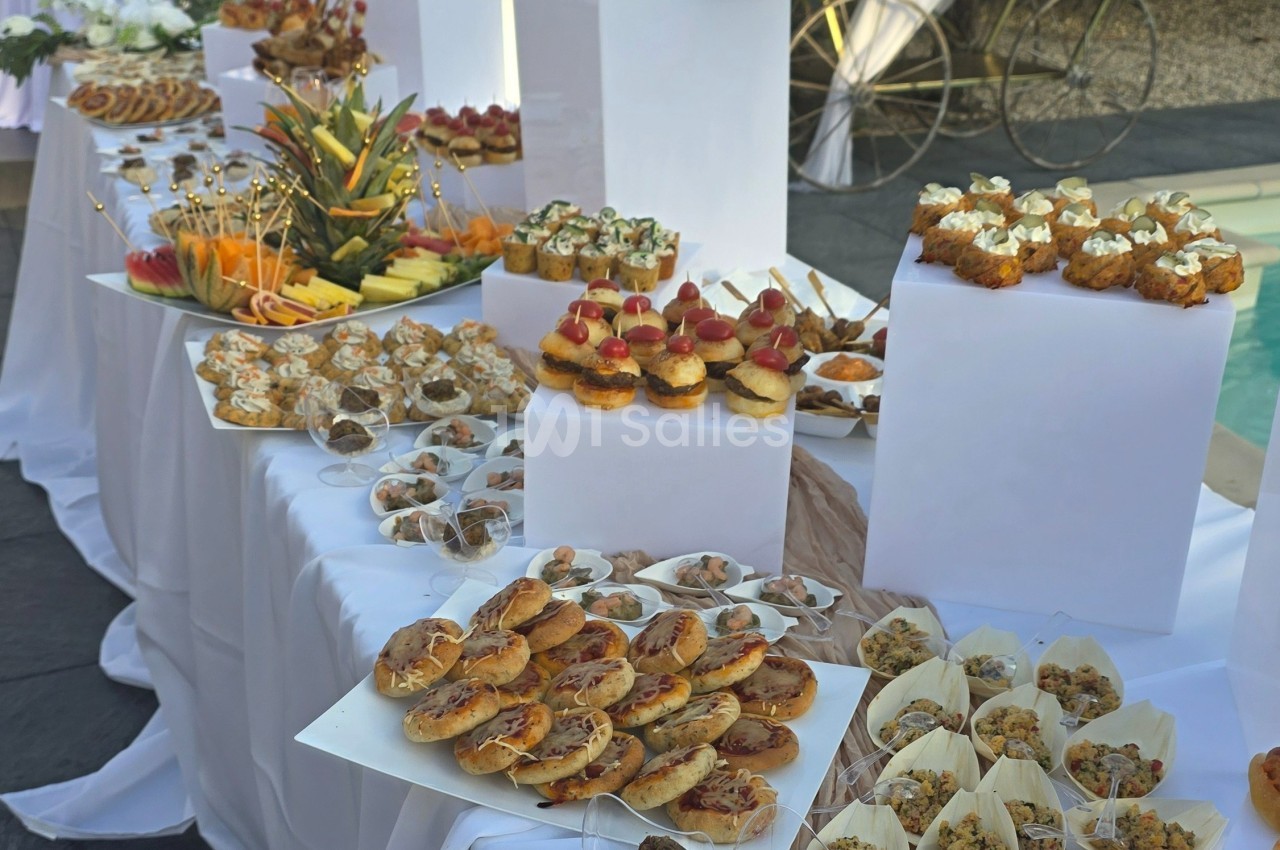 Buffet de petits fours variés disposés sur des tables blanches, avec des présentations soignées et colorées.