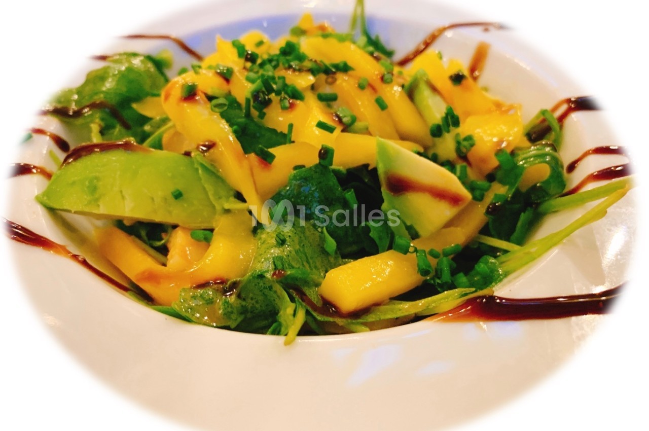 Salade colorée avec mangue, avocat, roquette, ciboulette et filet de sauce balsamique.