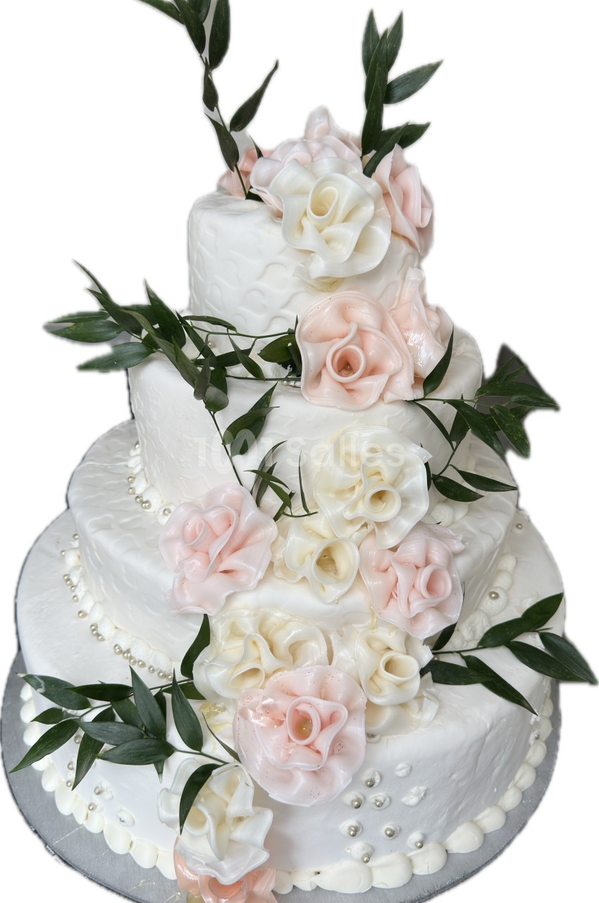 Gâteau de mariage à quatre étages décoré de roses en sucre blanches et roses, avec des feuilles vertes.
