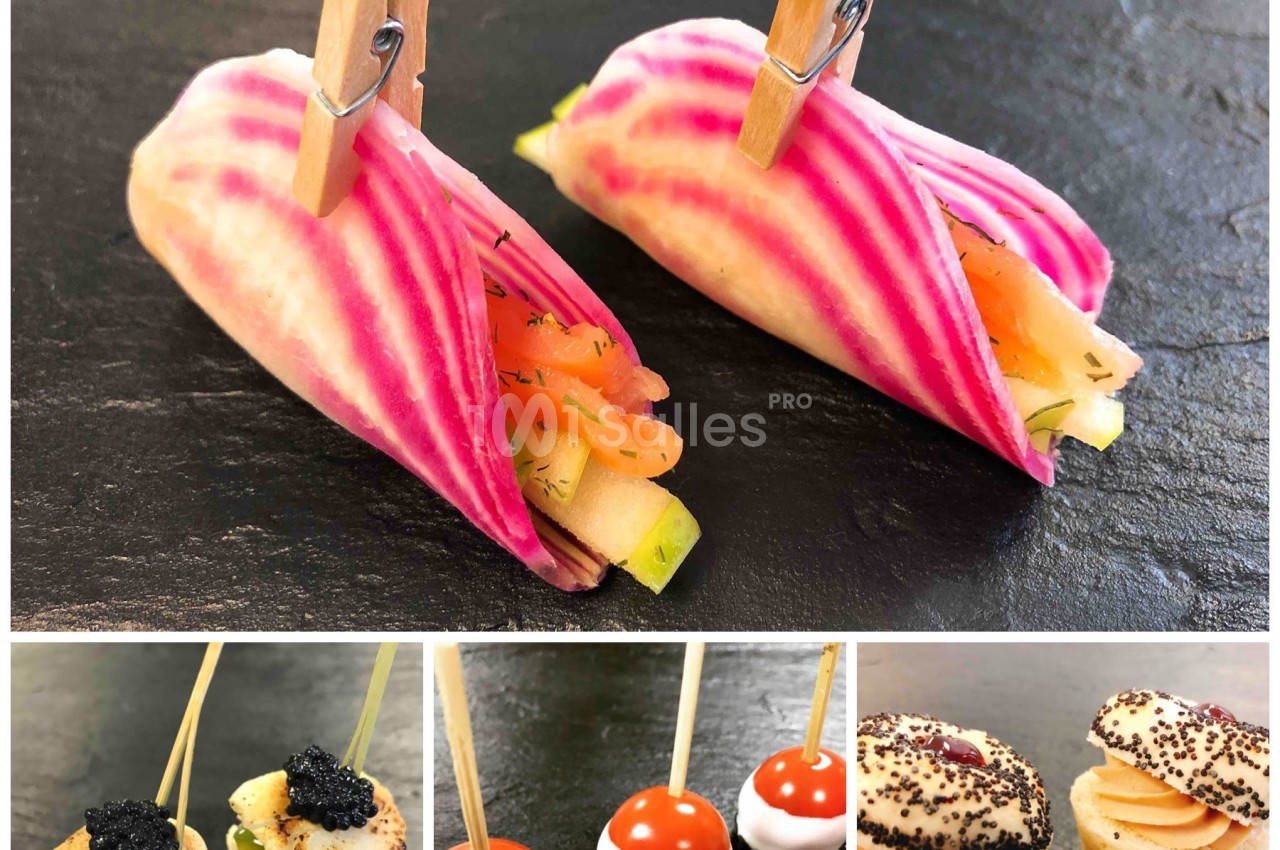 Assortiment de bouchées apéritives élégantes, incluant légumes, brochettes et mini-sandwichs sur ardoise noire.