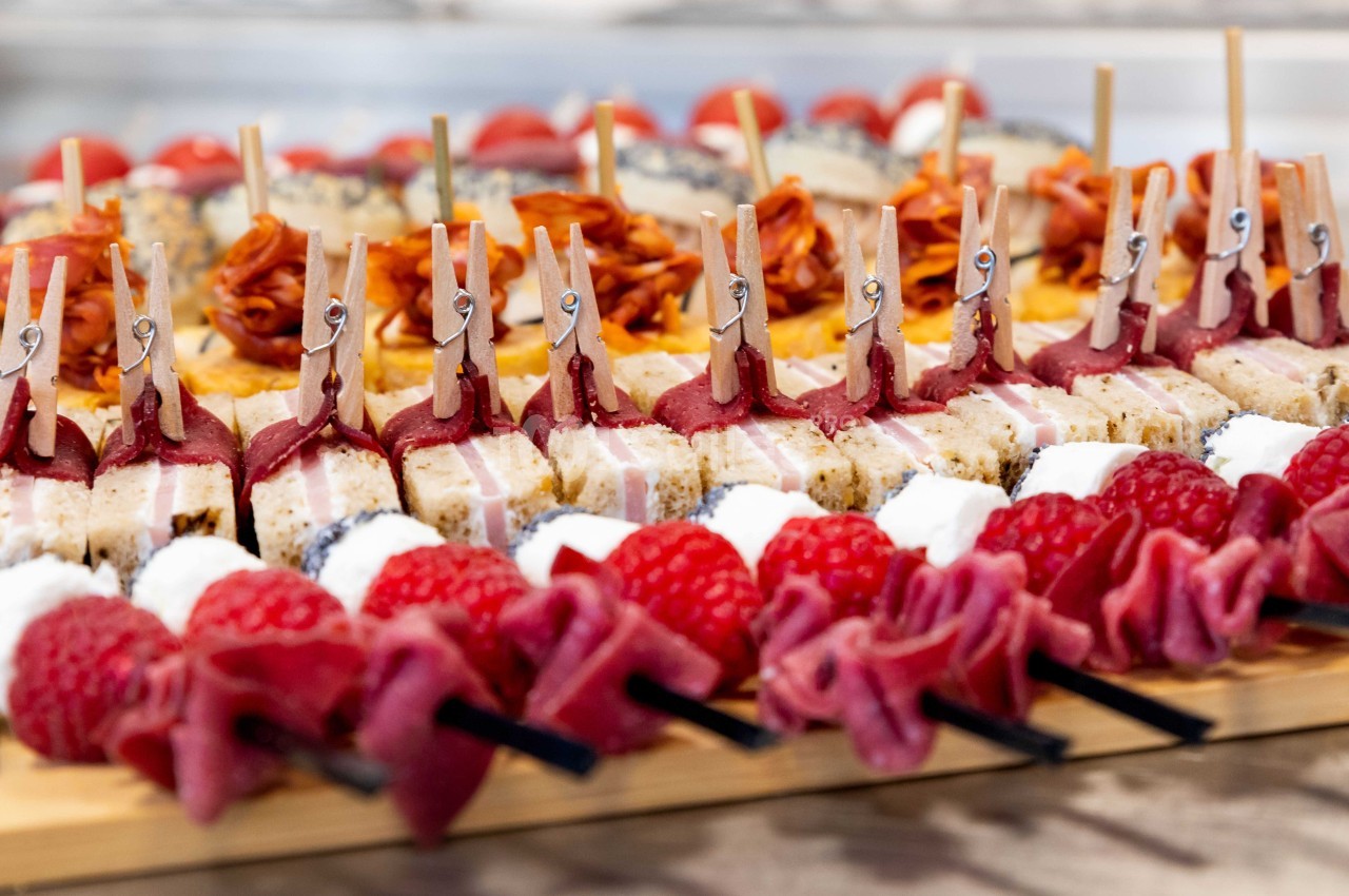 Plateau de brochettes apéritives avec fruits, fromages, charcuteries et décorations en mini-pinces à linge.