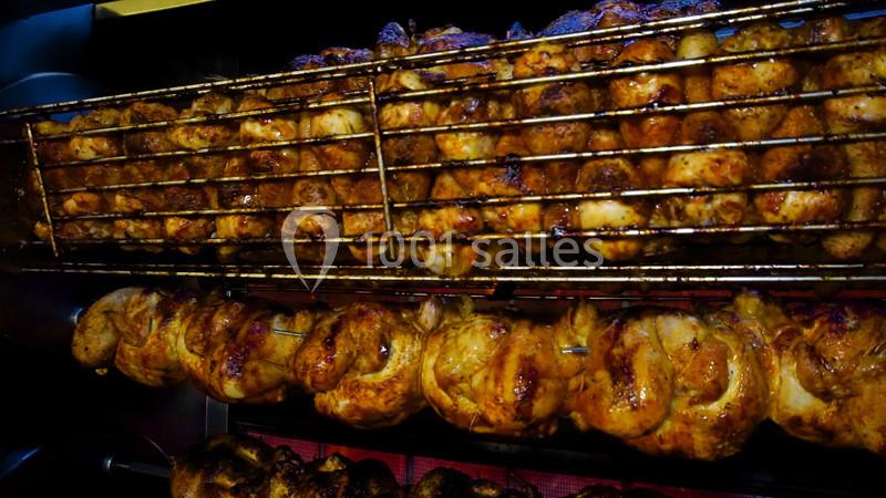 Poulets rôtis dorés tournant sur des broches dans un four à rôtisserie.