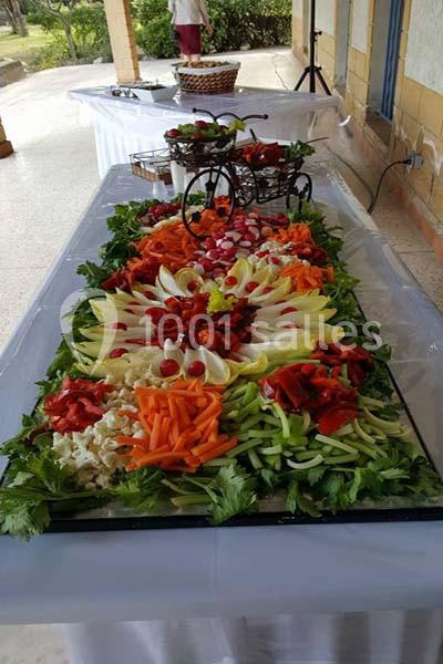 Plateau de crudités coloré avec carottes, concombres, endives, radis et poivrons, décoré d'un vélo miniature.