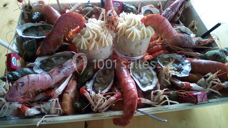 Plateau de fruits de mer avec crevettes, huîtres, bulots et deux portions de mousse décorative au centre.