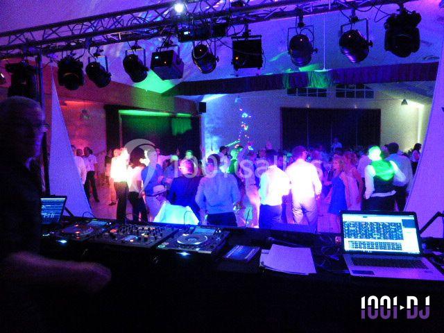 Vue d'une soirée dansante avec une piste éclairée de lumières colorées, vue depuis la table du DJ.