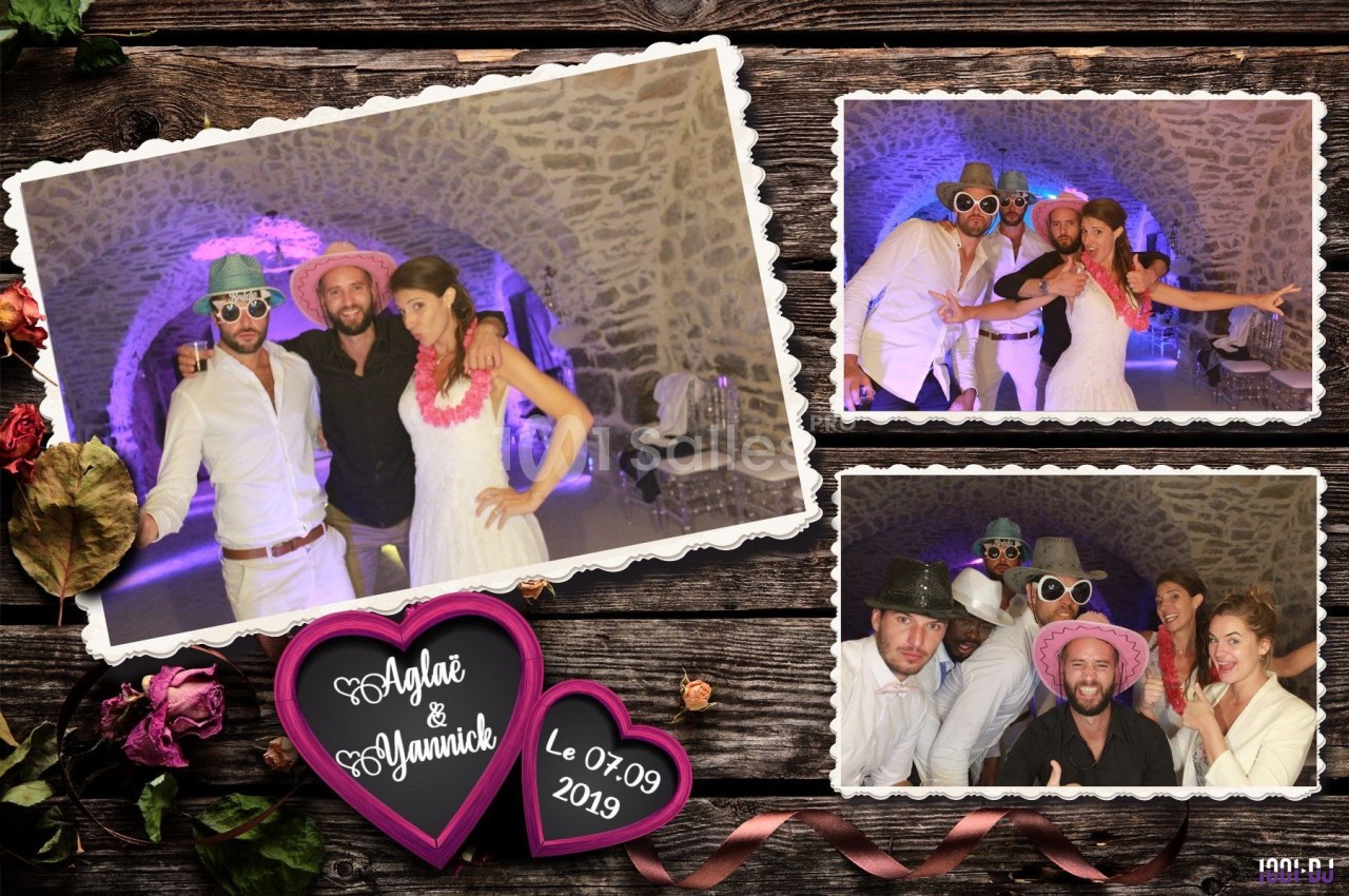 Des invités déguisés posent dans un photobooth lors d'un mariage, avec un décor en pierre et des accessoires festifs.