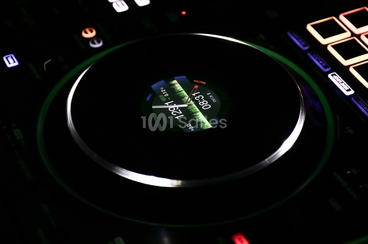 Platine de DJ avec écran central affichant une onde sonore lumineuse, entourée de commandes rétroéclairées.