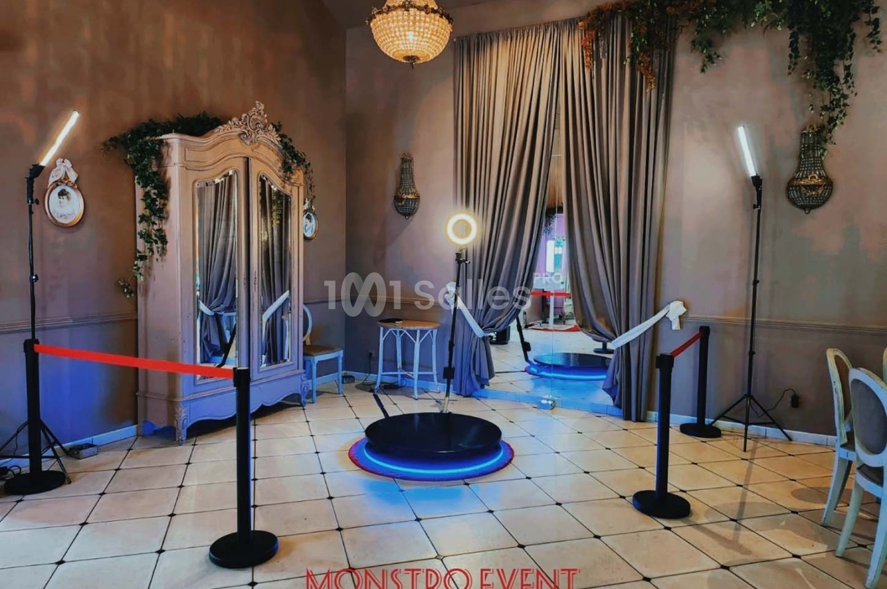 Plateforme circulaire entourée de lampes et de rideaux dans une pièce décorée avec un miroir et un mobilier élégant.