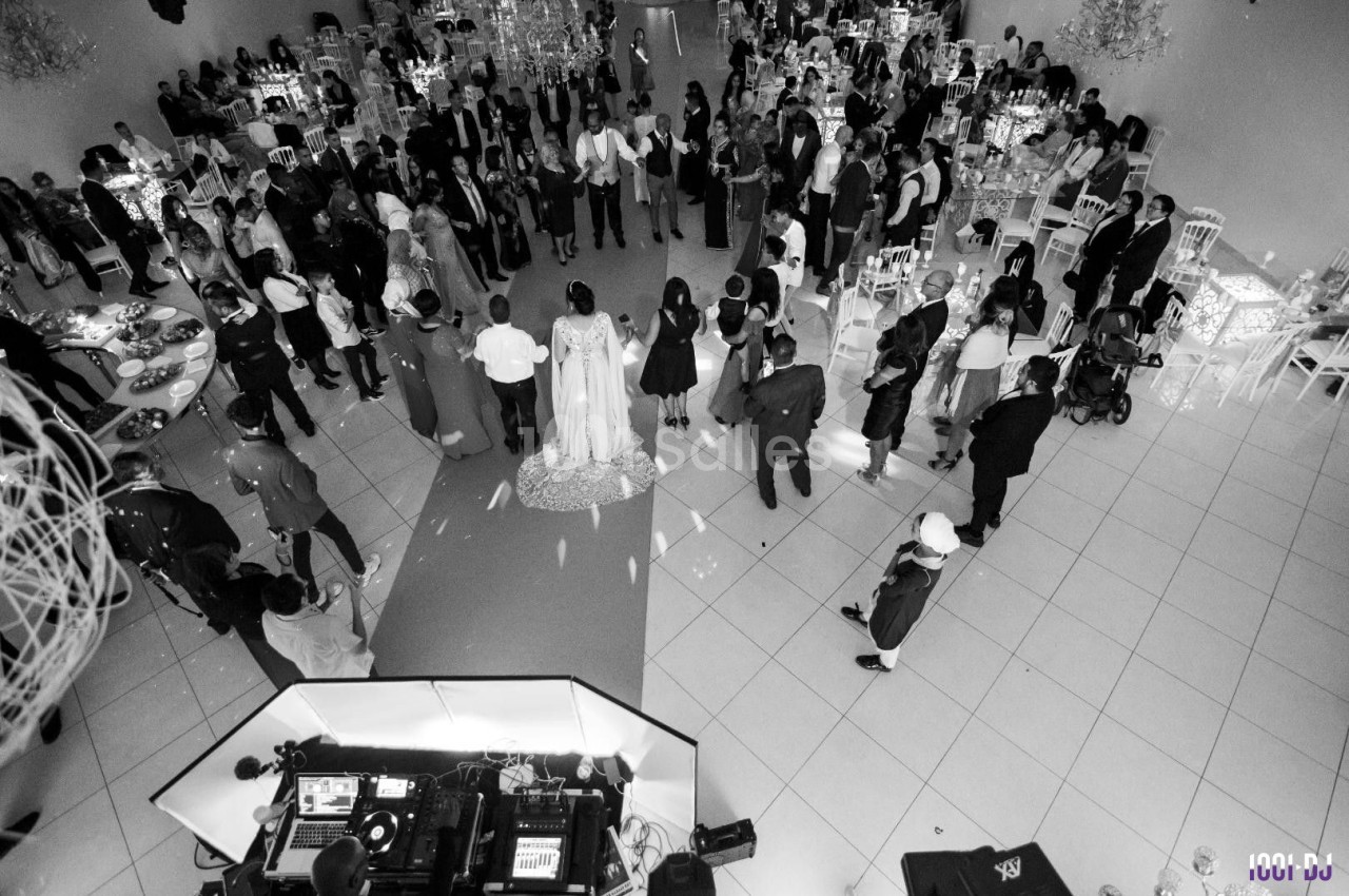 Vue aérienne en noir et blanc d'une réception de mariage avec des invités rassemblés autour des mariés.