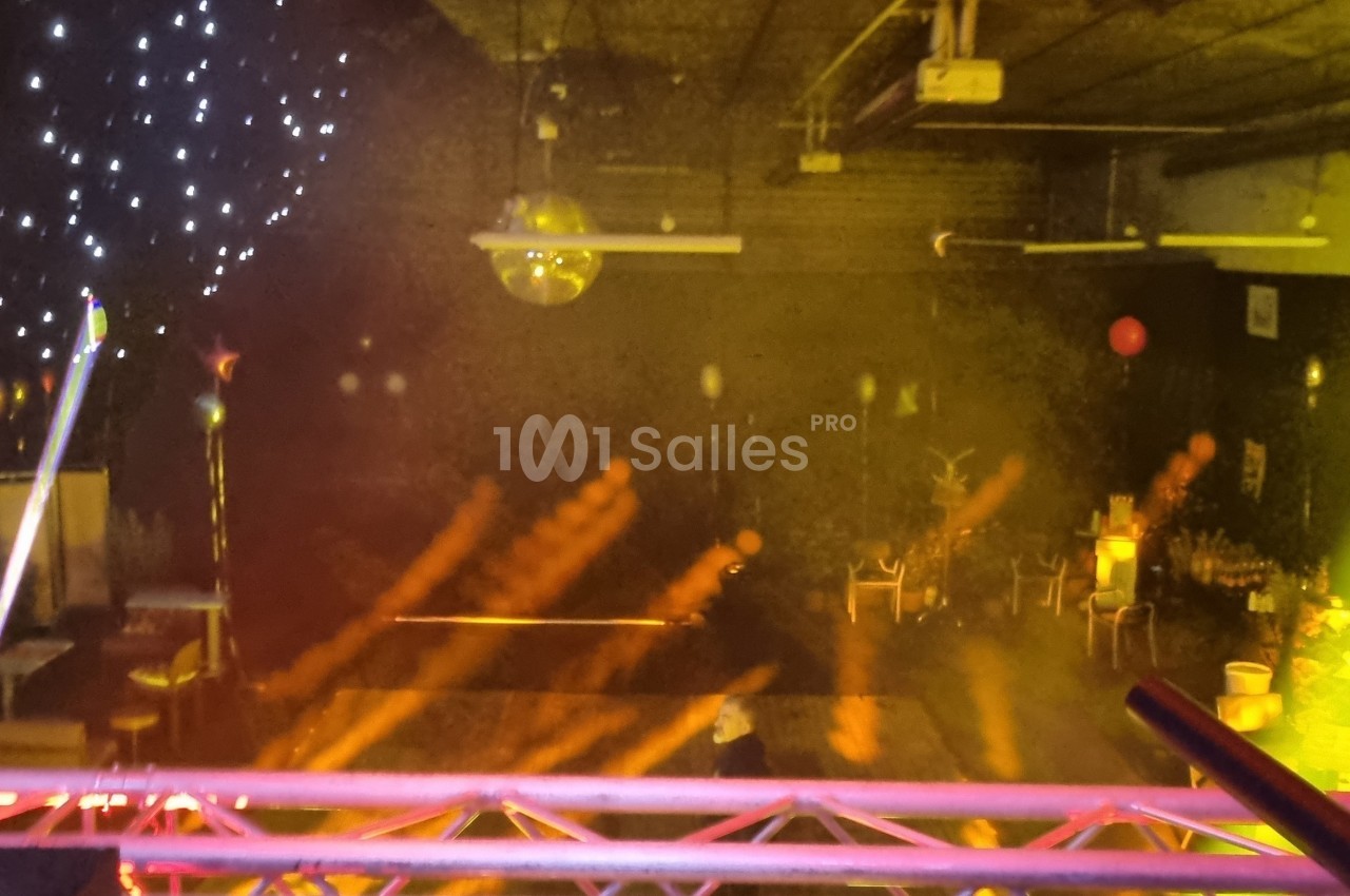 Salle de réception avec éclairage coloré, projecteurs, décorations lumineuses et ambiance festive.