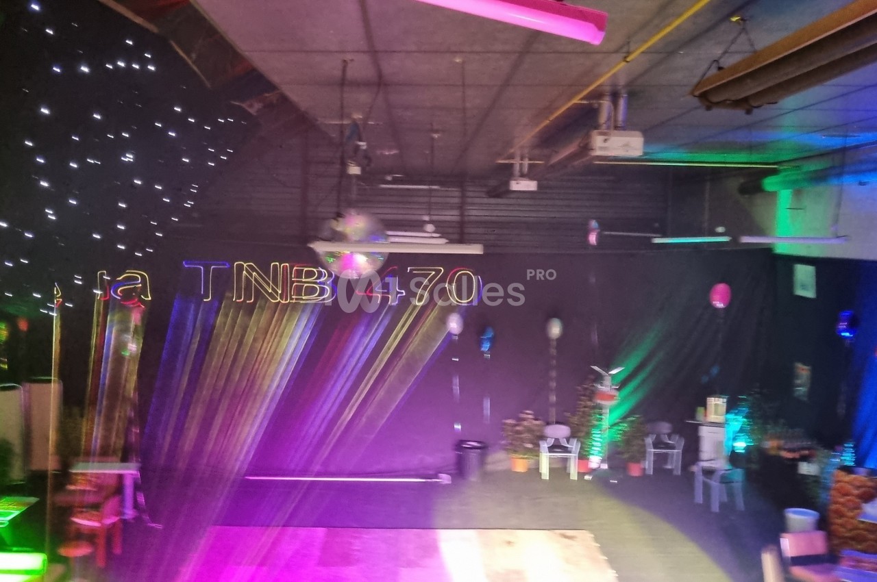 Salle décorée avec des lumières colorées, des étoiles suspendues et des lettres ’TNB 470’ illuminées.