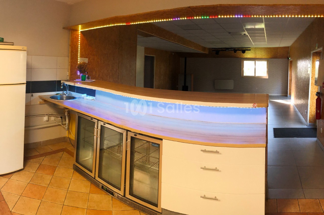 Comptoir en bois avec éclairage LED, équipé de réfrigérateurs en dessous, dans une pièce spacieuse et lumineuse.