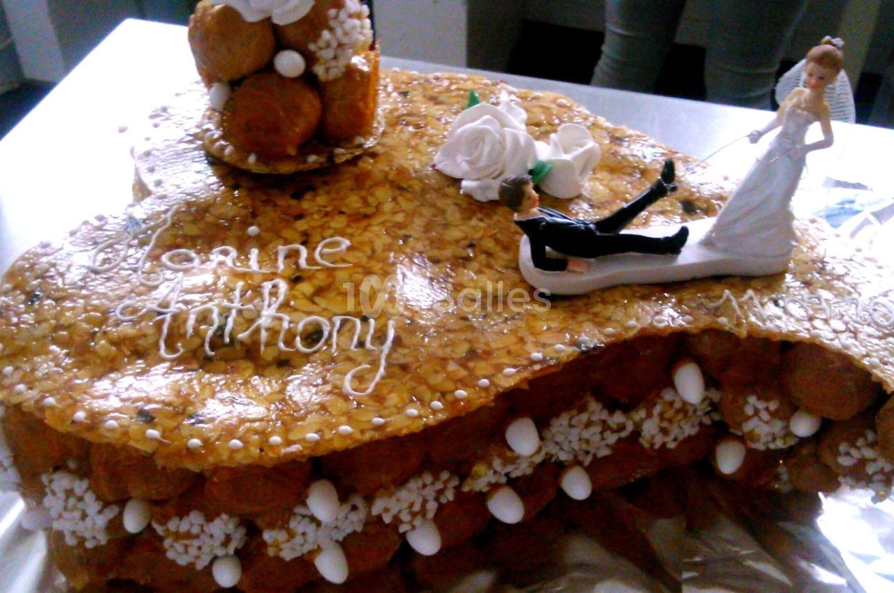 Pièce montée en choux caramélisés décorée de roses en sucre, d'une figurine de mariée et d'un message personnalisé.
