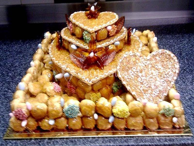 Pièce montée en choux caramélisés décorée de formes en sucre, dragées colorées et motifs en pâte d'amande.
