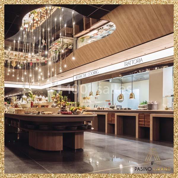Buffet gastronomique avec îlot central, cuisine ouverte et éclairage suspendu dans un espace moderne et élégant.