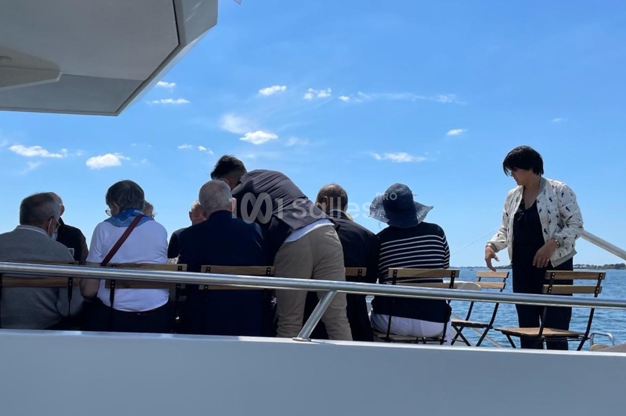 Un groupe de personnes assises à l'arrière d'un bateau, profitant d'une journée ensoleillée sur l'eau.