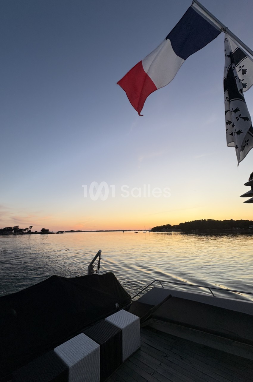 Drapeaux français et breton flottant au-dessus d'un ponton au bord d'un lac au coucher du soleil.