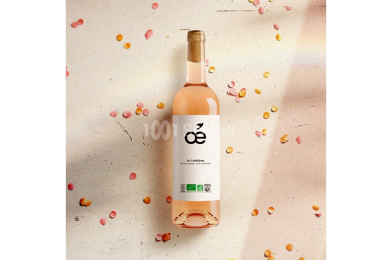 Bouteille de vin rosé posée sur une surface claire, entourée de confettis colorés.