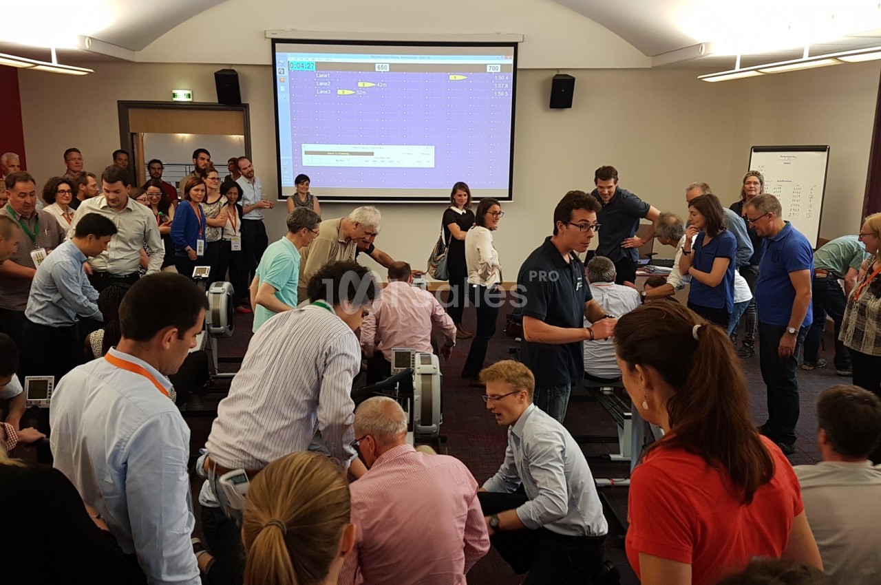 Des personnes participent à une activité collaborative dans une salle de conférence équipée d'un écran de projection.