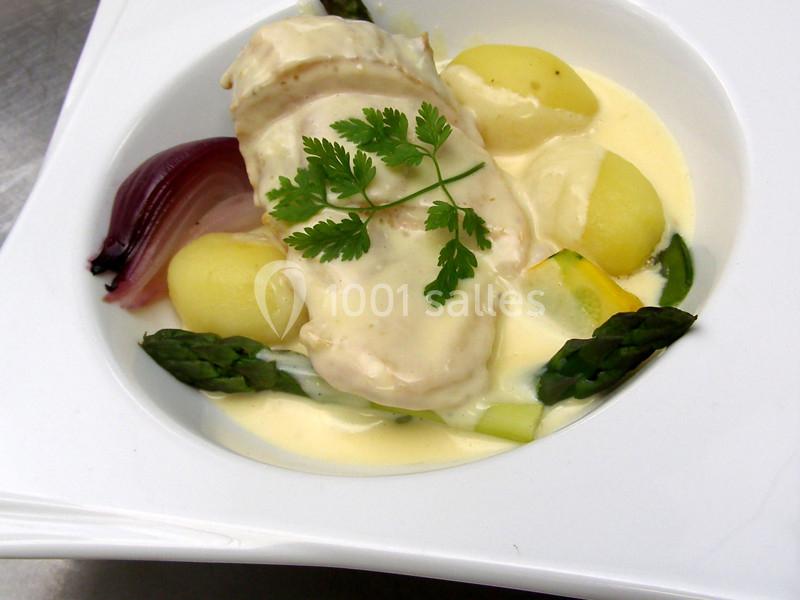 Assiette de poulet nappé de sauce crémeuse, accompagné de pommes de terre, asperges et oignon rouge.