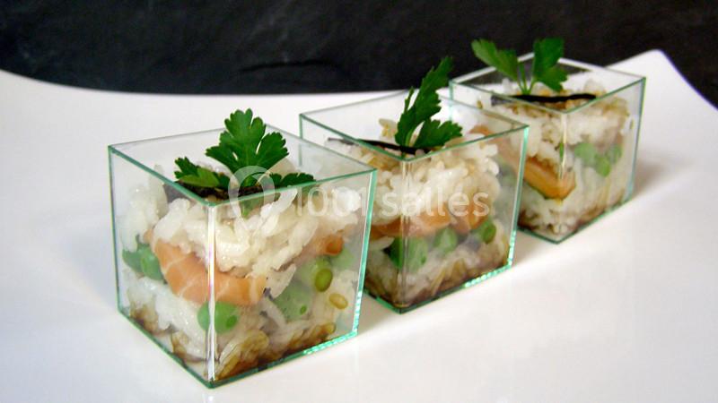 Trois verrines contenant un mélange de riz, légumes verts, saumon et décorées de feuilles de persil.