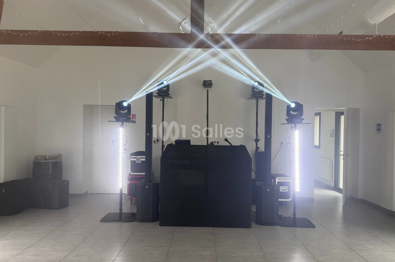 Installation de matériel de sonorisation et d'éclairage avec projecteurs et lumières dans une salle vide.