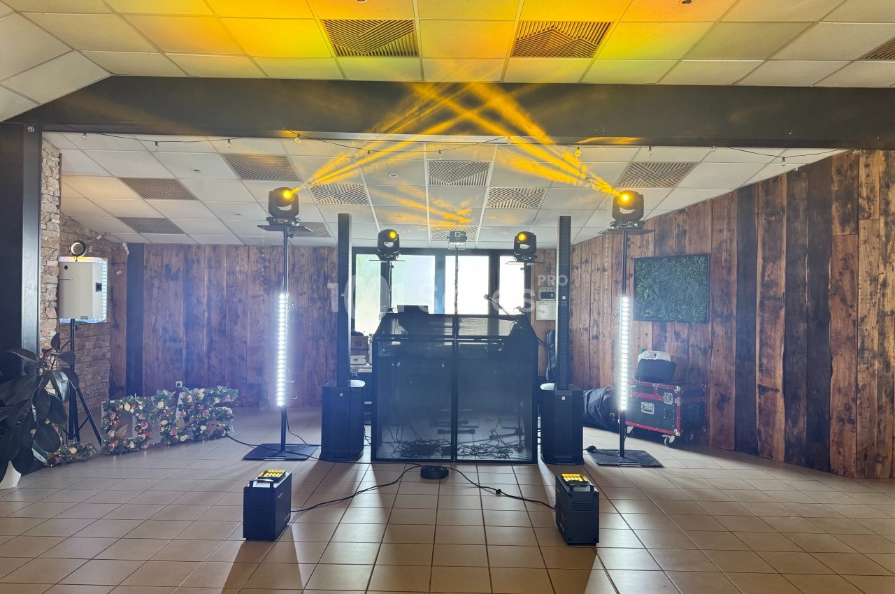 Installation de matériel de sonorisation et éclairage avec projecteurs jaunes dans une salle au décor boisé.
