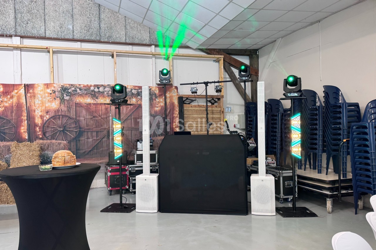 Installation de matériel de sonorisation et d'éclairage dans une salle décorée avec des éléments rustiques.