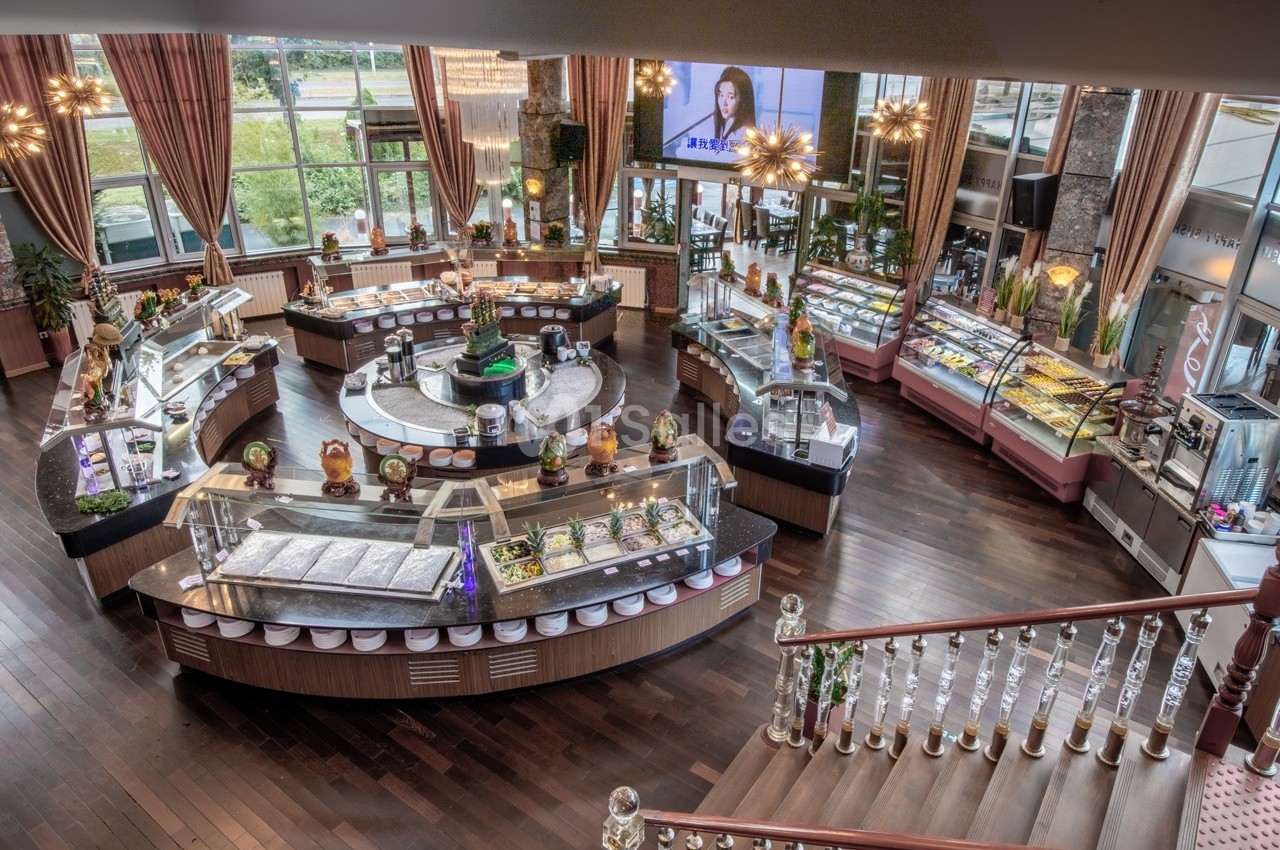 Vue intérieure d'une pâtisserie ou d'un buffet avec des vitrines remplies de desserts, éclairage chaleureux et décoration…