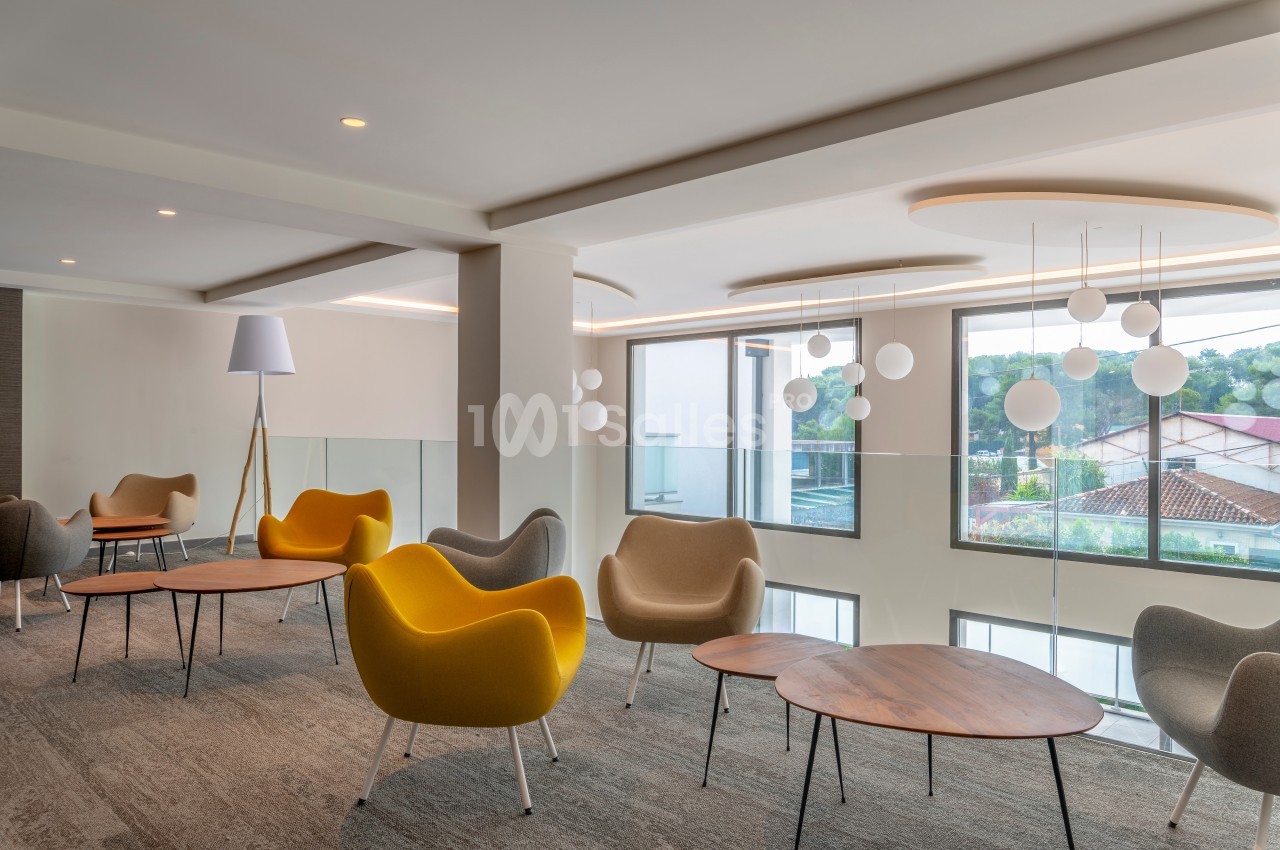 Espace lumineux avec des fauteuils modernes, des tables basses en bois et des suspensions sphériques près de grandes…