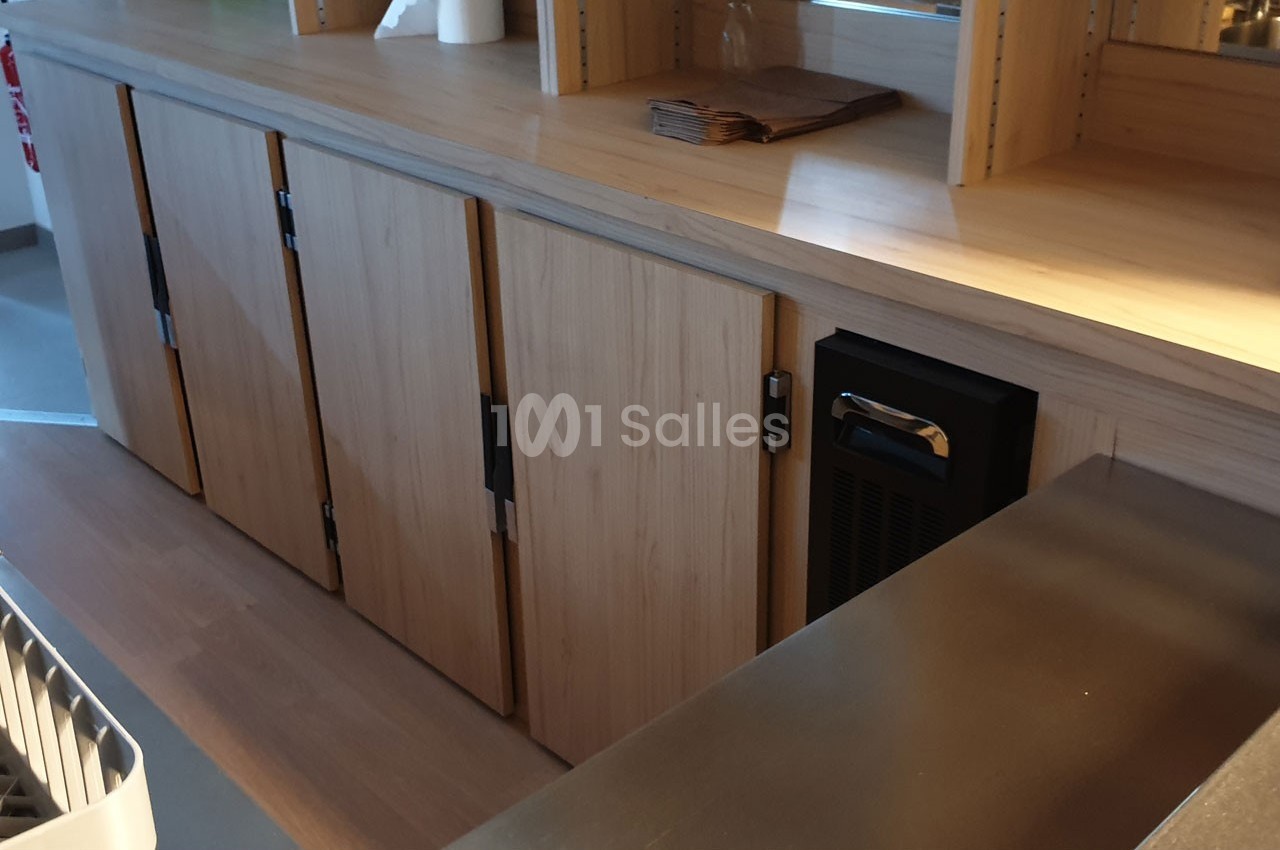 Meuble en bois clair avec plusieurs portes fermées, situé dans un espace intérieur moderne et lumineux.