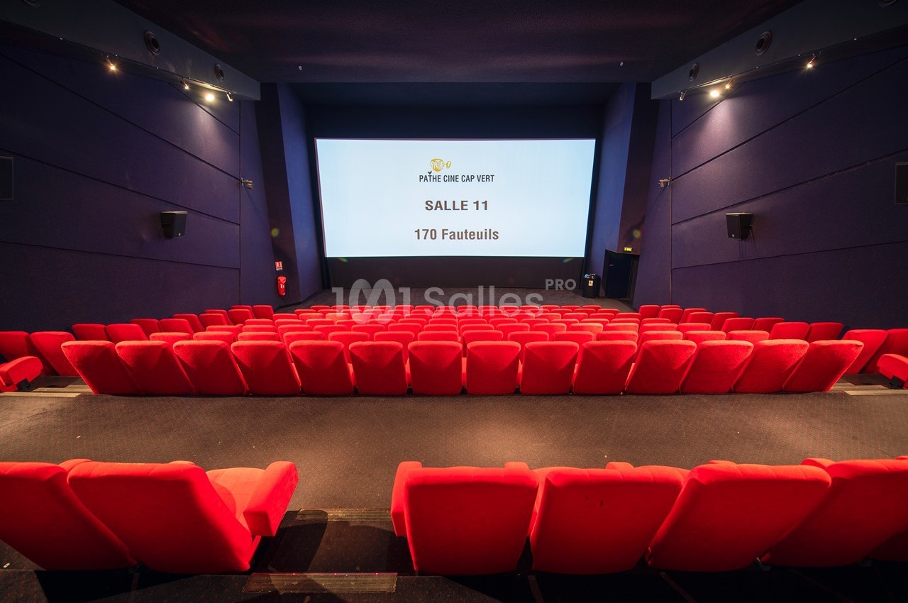 Salle de cinéma vide avec des rangées de fauteuils rouges et un écran affichant ’Salle 11, 170 fauteuils’.