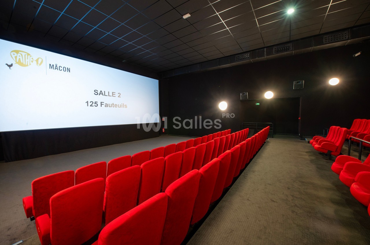 Salle de cinéma vide avec des rangées de fauteuils rouges, un écran affichant ’Salle 2 - 125 fauteuils’.