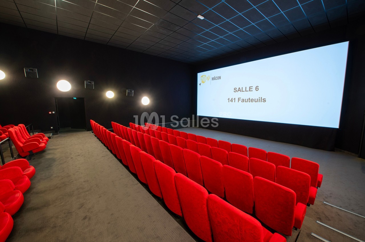 Salle de cinéma vide avec des rangées de fauteuils rouges et un écran affichant ’Salle 6 - 141 fauteuils’.