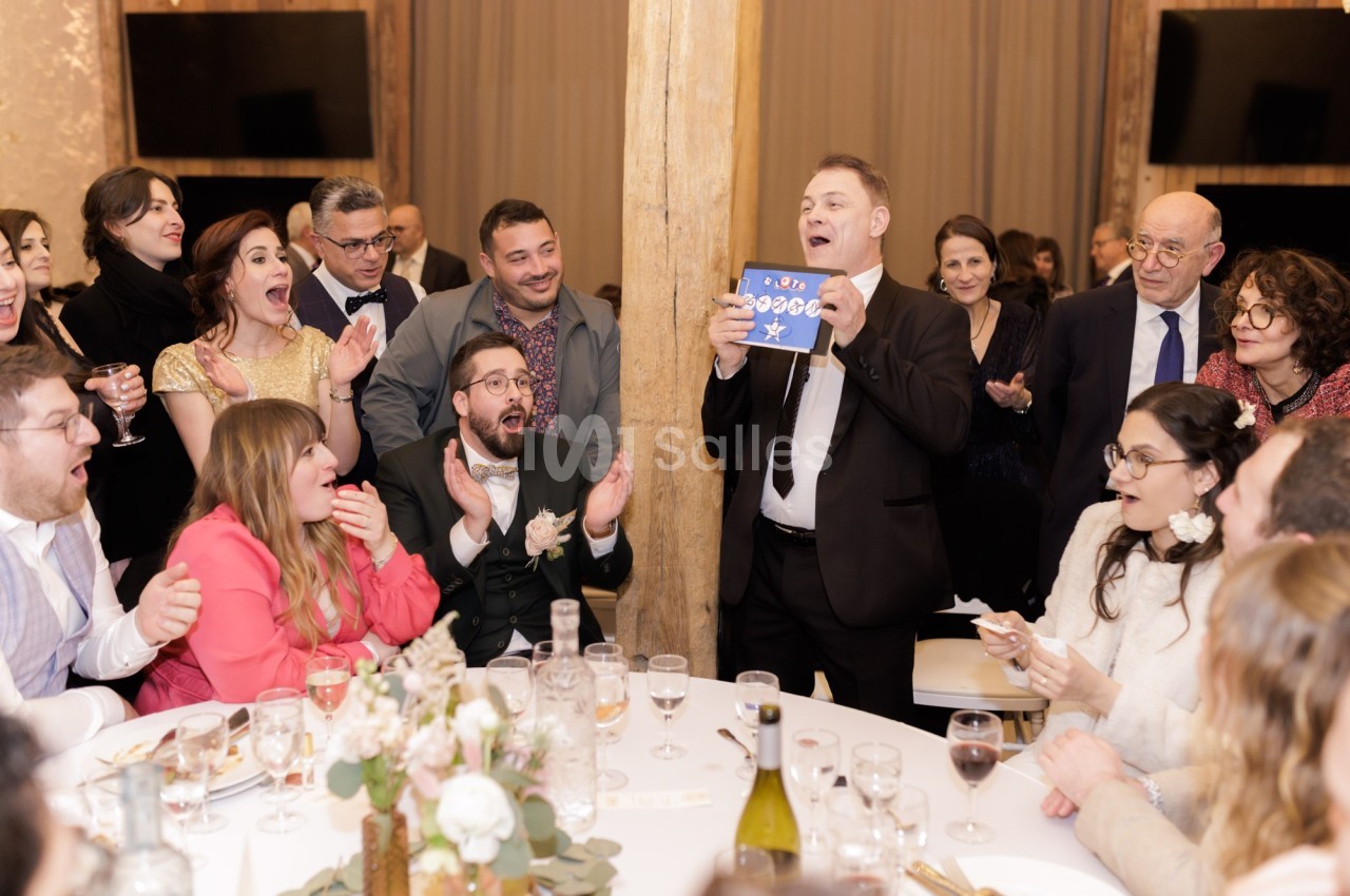 Un groupe de personnes autour d'une table lors d'une fête, réagissant avec enthousiasme à une présentation.