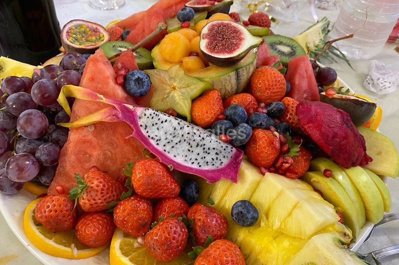 Assiette garnie de fruits variés tels que fraises, pastèque, ananas, kiwis, figues, raisins et fruits exotiques.