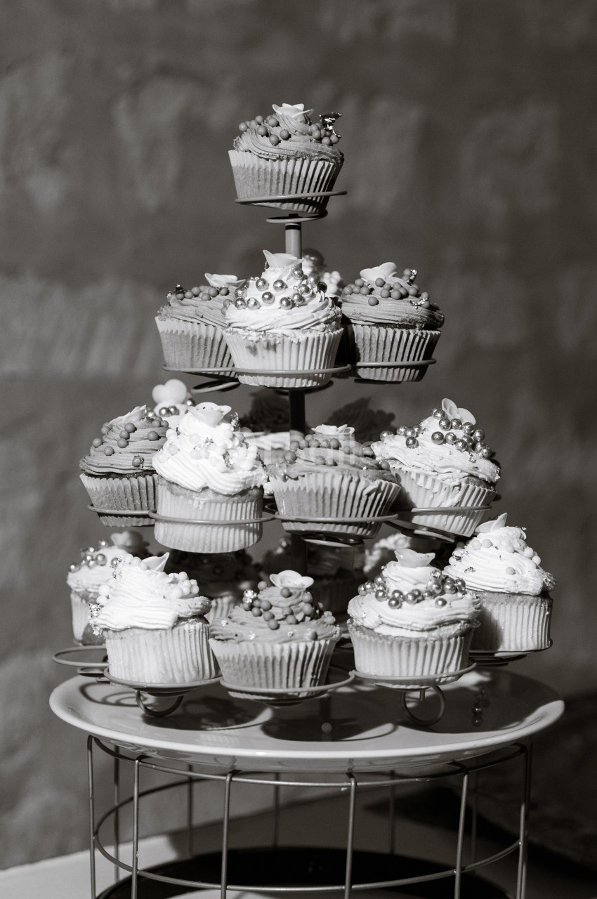 Présentoir à plusieurs étages garni de cupcakes décorés de perles et de fleurs en sucre.