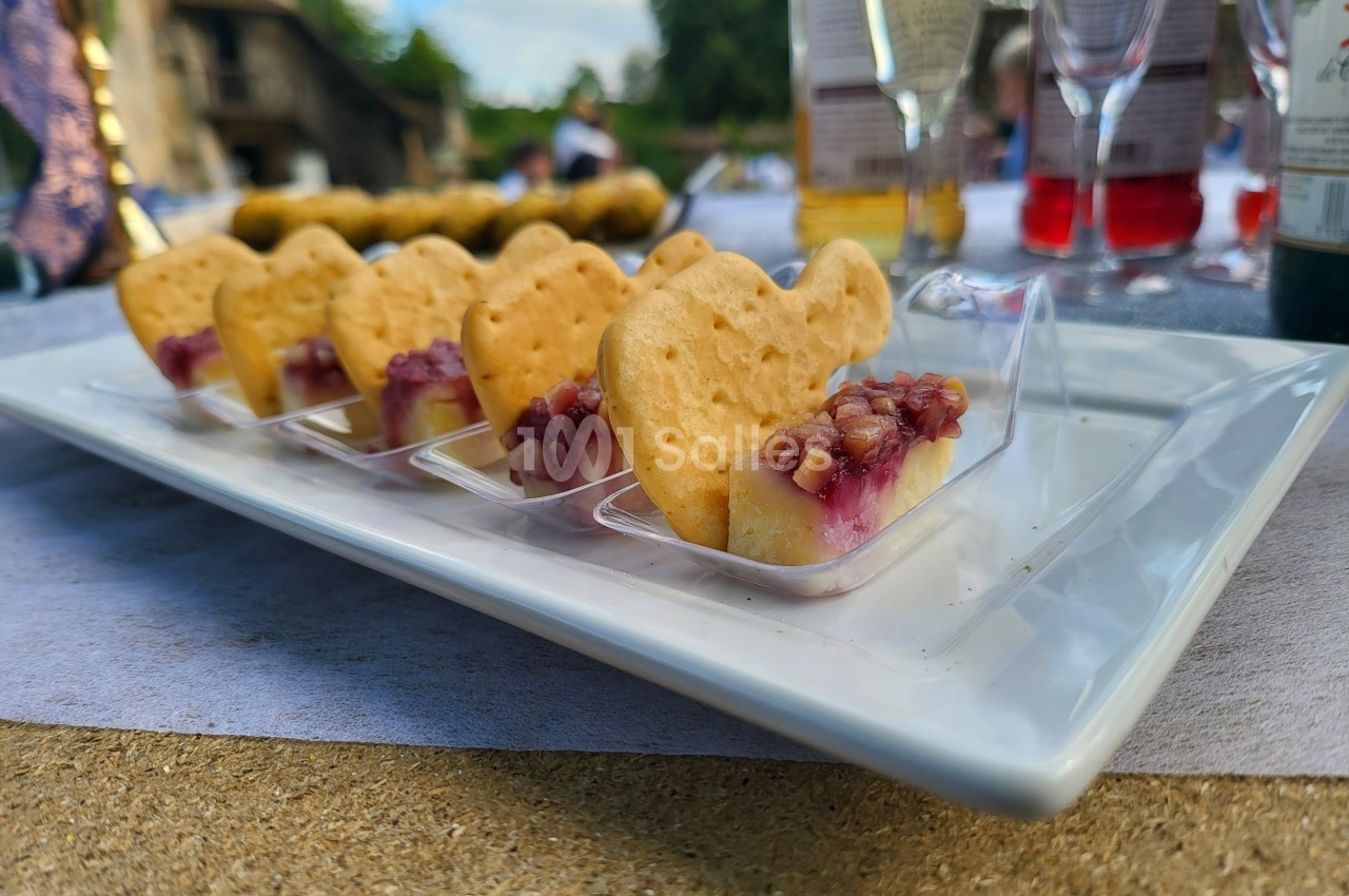 Assortiment de bouchées apéritives avec fromage, confiture et biscuits, présenté sur une assiette blanche.