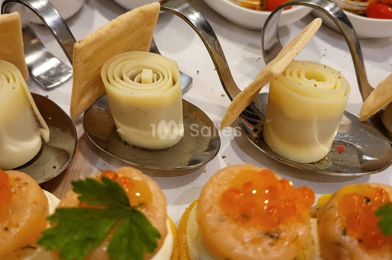 Assortiment de bouchées apéritives avec roulés de fromage, crackers et canapés au saumon et œufs de poisson.