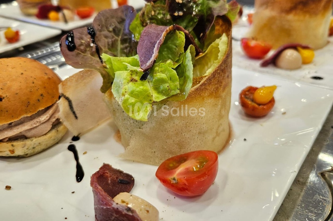 Assiette composée d'une salade en corolle de pâte croustillante, tomates cerises et garnitures variées.