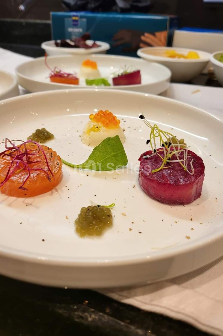Assiette de dégustation avec saumon, betterave, caviar et garnitures, présentée de manière raffinée.